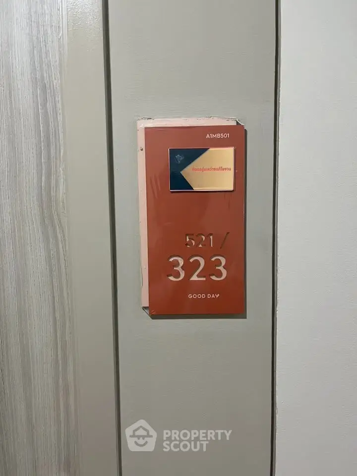 Modern apartment door with stylish room number plaque and keycard holder.