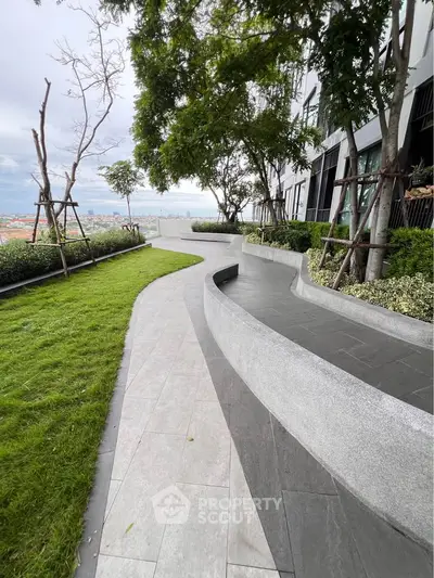 Modern building exterior with lush garden and scenic pathway offering serene views.