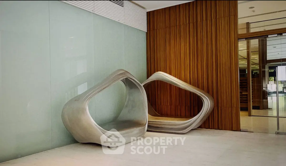 Modern lobby with unique sculptural seating and sleek wooden paneling.