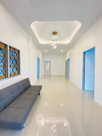 Spacious modern living room with sleek sofa and elegant ceiling lights