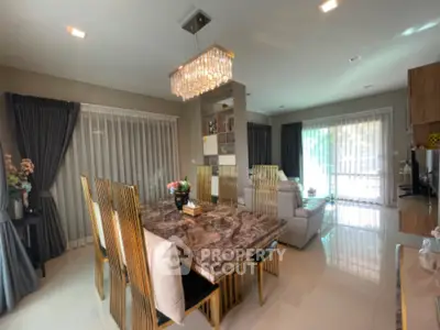 Luxurious open-plan living and dining area with elegant chandelier and modern decor