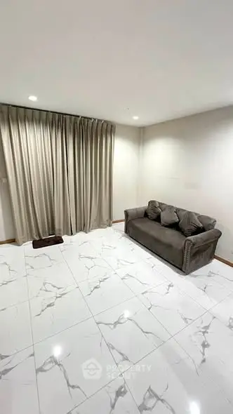 Modern living room with elegant marble flooring and cozy sofa, perfect for relaxation.