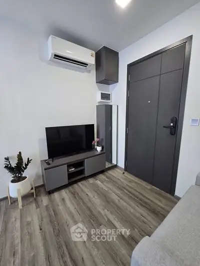 Modern living room with sleek design, featuring air conditioning and stylish flooring.
