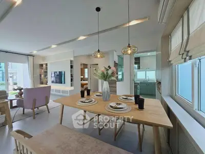 Spacious modern living room with elegant dining area and open kitchen layout, featuring stylish decor and ample natural light.