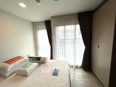 Spacious bedroom with large windows and elegant curtains in modern apartment