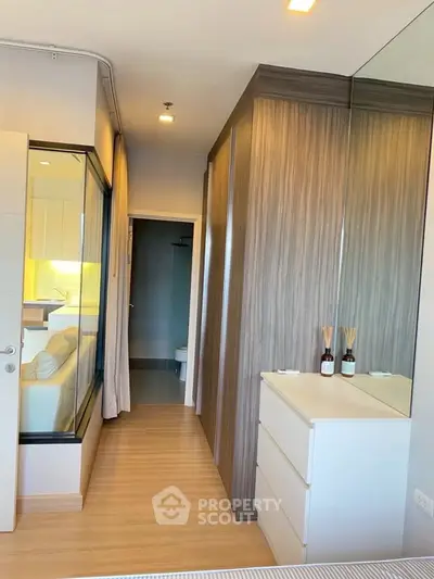 Modern bedroom with wooden flooring and mirrored wardrobe in stylish apartment