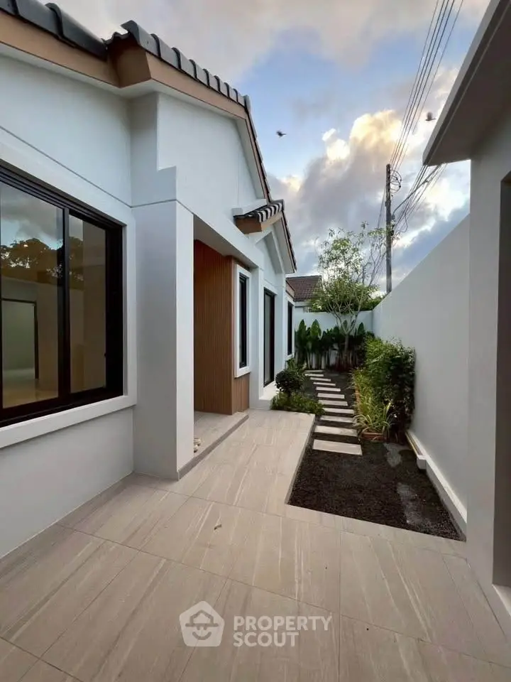 Modern exterior view of a stylish home with sleek design and lush garden path.