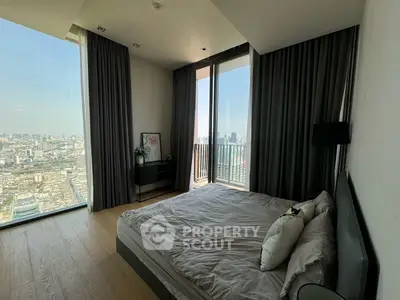Luxurious bedroom with stunning city view and floor-to-ceiling windows in modern high-rise apartment.