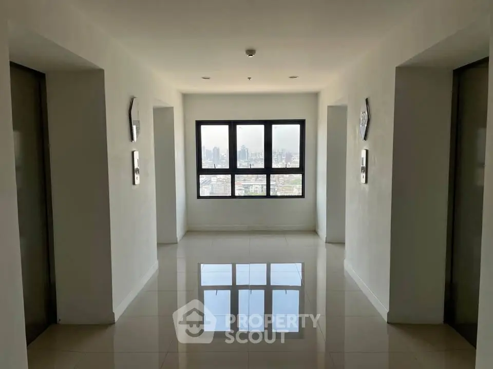 Spacious modern corridor with city view from large window, ideal for urban living.