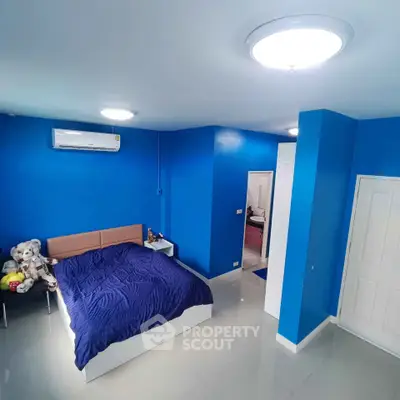 Spacious blue-themed bedroom with modern lighting and air conditioning