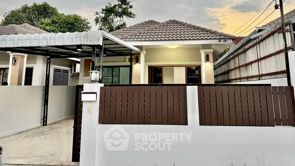 Charming single-story home with modern facade and gated driveway in serene neighborhood.