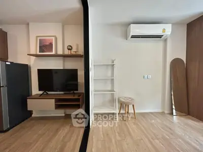 Modern living room with sleek TV setup and air conditioning, perfect for comfort and style.