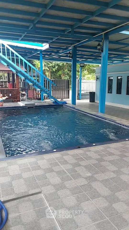 Spacious covered pool area with modern design and outdoor seating.