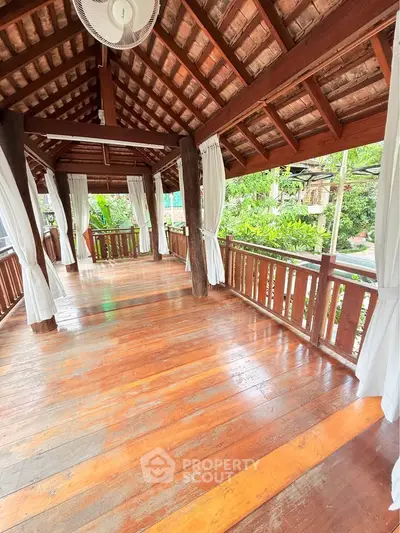 Charming wooden balcony with lush garden views, perfect for relaxation and outdoor enjoyment.