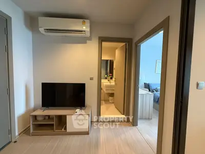 Modern apartment interior with air-conditioned living room and view into bedroom and bathroom.