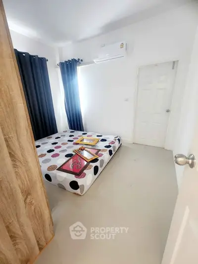 Cozy bedroom with modern decor and natural light, perfect for relaxation and comfort.