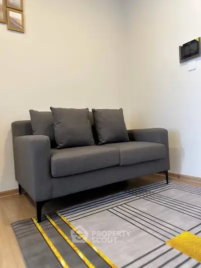 Modern living room with stylish gray sofa and geometric rug