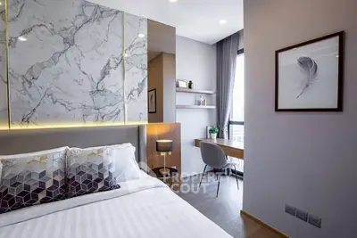 Modern bedroom with elegant marble accent wall and cozy workspace by the window.