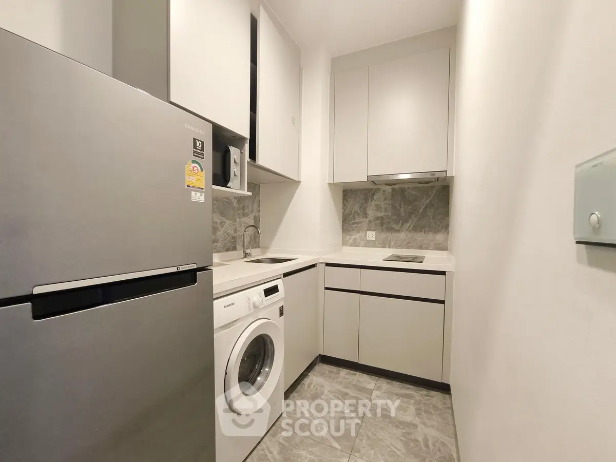 Modern compact kitchen with sleek appliances and minimalist design