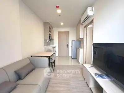 Modern living room with sleek furniture and integrated kitchen in a stylish apartment.