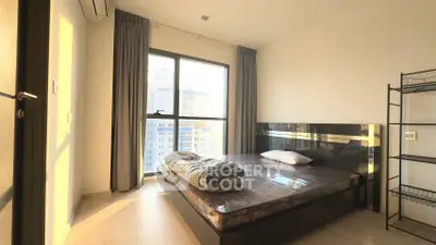 Modern bedroom with large window and city view, featuring minimalist design and natural light.