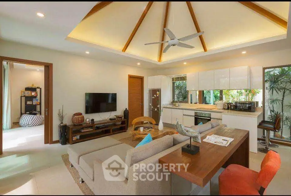 Stunning open-layout living room with modern kitchen and high ceilings in tropical home.