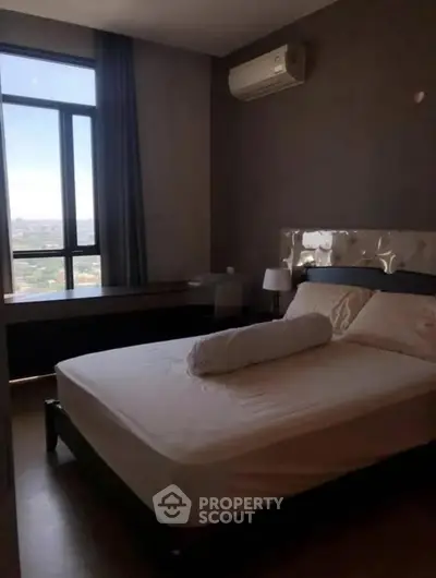 Modern bedroom with large window and air conditioning in high-rise apartment.