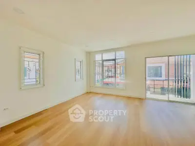 Spacious empty living room with large windows and wooden flooring