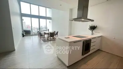 Spacious modern kitchen with open layout and city view, featuring sleek cabinetry and dining area.