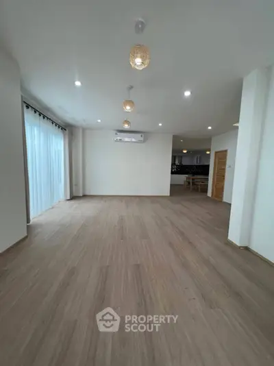 Spacious modern living room with wooden flooring and elegant lighting