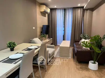 Modern living room with stylish decor and natural light, featuring a cozy seating area and dining space.