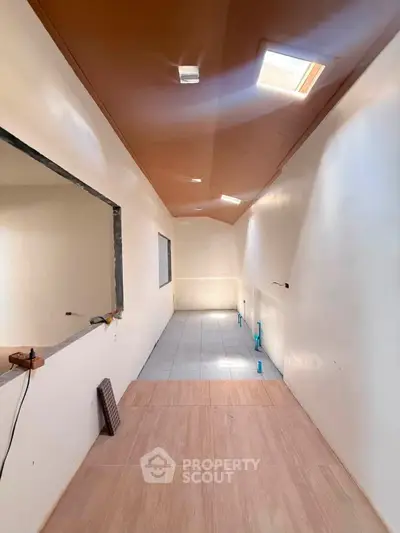 Spacious hallway with skylight and modern design, perfect for natural light lovers.