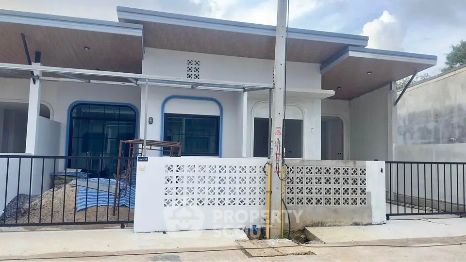 Modern single-story house with a sleek facade and covered porch, featuring a stylish blue and white color scheme.