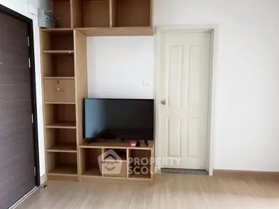 Modern living room with wooden shelves and flat-screen TV, perfect for cozy entertainment.