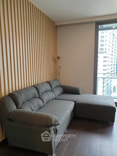 Modern living room with stylish sofa and city view from window