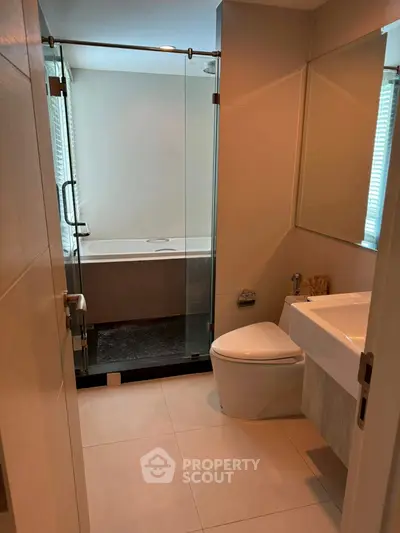 Modern bathroom with glass shower and sleek fixtures in a contemporary apartment.