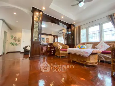 Spacious living room with elegant wooden flooring and cozy wicker furniture.