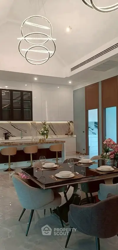Luxurious modern kitchen with elegant dining area and stylish lighting fixtures.