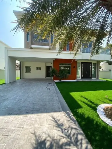 Modern two-story house with lush green lawn and spacious driveway