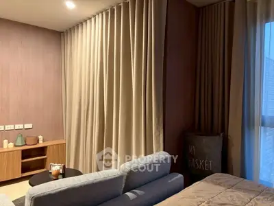 Cozy living room with modern decor and soft lighting, featuring a comfortable sofa and elegant curtains.