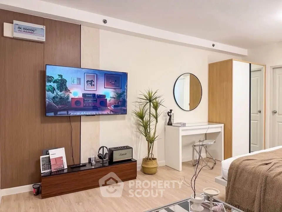 Modern living room with stylish decor, wall-mounted TV, and sleek furniture in a cozy apartment.