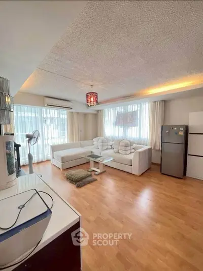 Spacious living room with modern decor and large windows for natural light