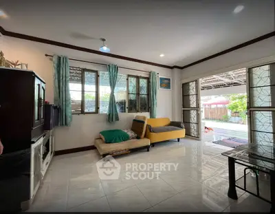Spacious living room with large windows and modern decor, perfect for family gatherings.