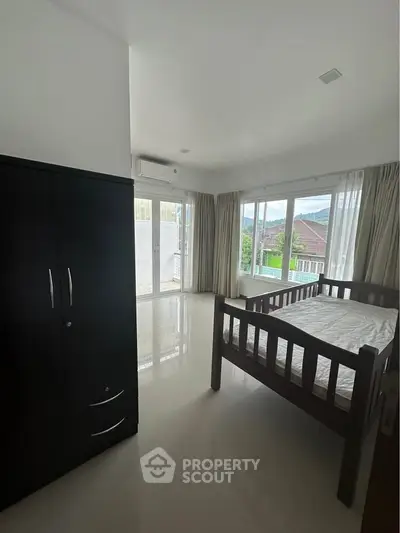 Spacious bedroom with large windows and scenic view