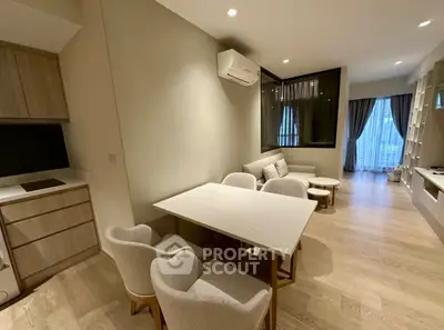 Modern living room with dining area, featuring elegant furniture and natural light.