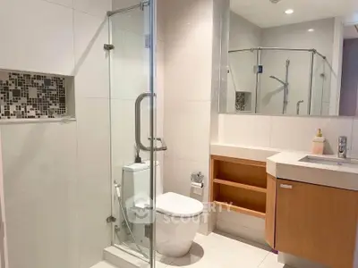 Modern bathroom with glass shower and sleek vanity in a contemporary home.