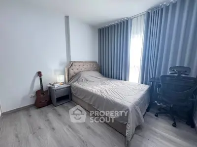Modern bedroom with stylish decor, featuring a cozy bed, guitar, and ergonomic chair, perfect for relaxation and creativity.