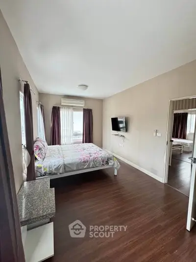 Spacious bedroom with modern decor and large windows for natural light