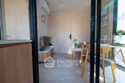 Modern living room with stylish decor and dining area, featuring natural light and contemporary furniture.