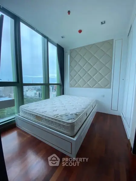 Luxurious bedroom with city view and elegant wooden flooring